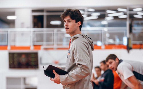 Student in gym holding journal.