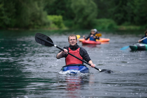 Student kayaking in a river.