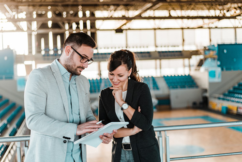 Student in a gym looking over a plan.